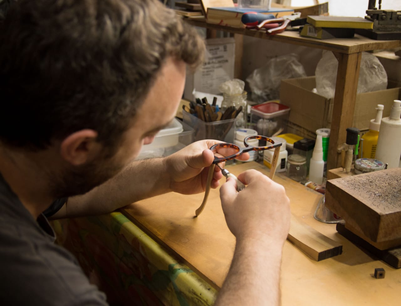 hombre en el taller trabajando en el ensamblado de un anteojo de madera y acetato